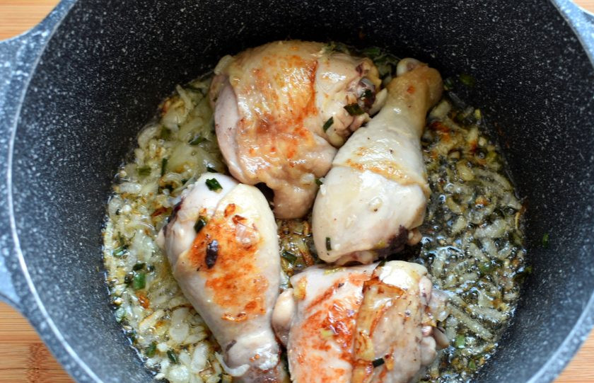 1. Этап. Филиппинский Арроз Кальдо: Выложите сверху разрезанные пополам окорочка и обжарьте до румяной корочки. Выньте окорочка на тарелку и всыпьте к луку промытый и обсушенный рис. Обжаривайте 3-4 минуты, помешивая.