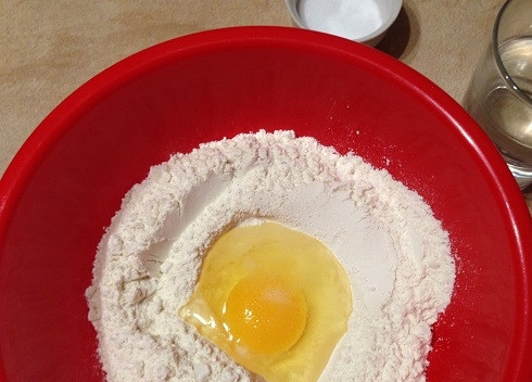 1. Этап. Квери с сыром: Первым делом приготовим тесто. Просеиваем в миску муку, добавляем яйцо и соль. И, добавив воду, замешиваем тесто. Оно должно получиться мягким и эластичным, поэтому вымешивать его необходимо минут 8-10.