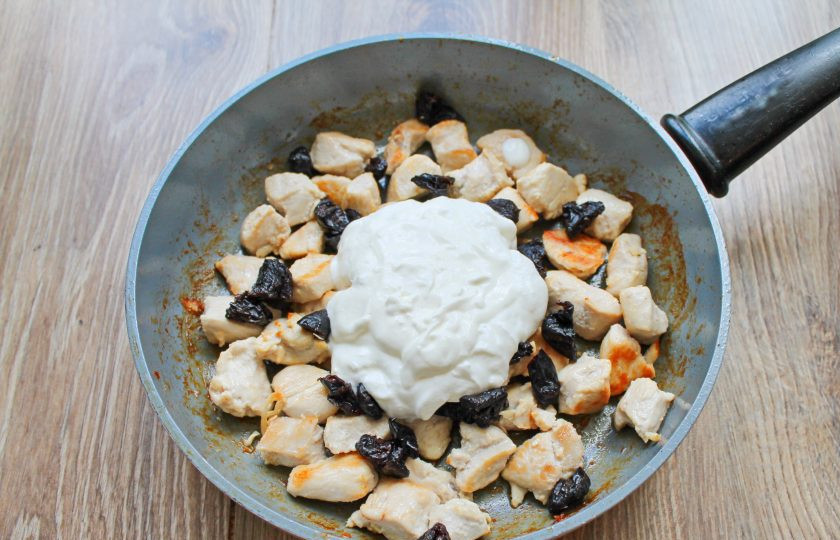 1. Этап. Куриное филе с черносливом: Добавьте сметану в сковороду с черносливом и курицей.