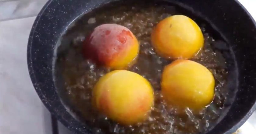 1. Этап. Вкусный десерт из персиков: 3. Разрежьте персики пополам и проверните, чтобы аккуратно разломить их, не повредив мякоть. Достаньте косточку. На раскаленную сковороду добавьте остатки вина, воду и сахарную пудру. Хорошо все размешайте и дайте соусу закипеть. Выложите в кипящий соус персики.