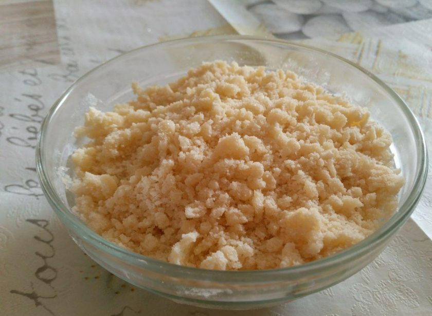 1. Этап. Тыквенный пирог с ягодами и штрейзелем: Пока тесто будет подниматься, приготовьте штрейзель. Для этого соедините 50 граммов сахарного песка, ванильный сахар, 100 граммов пшеничной муки и 50 граммов размягчённого сливочного масла (растапливать его не нужно). Разминайте смесь пальцами до образования крошки.