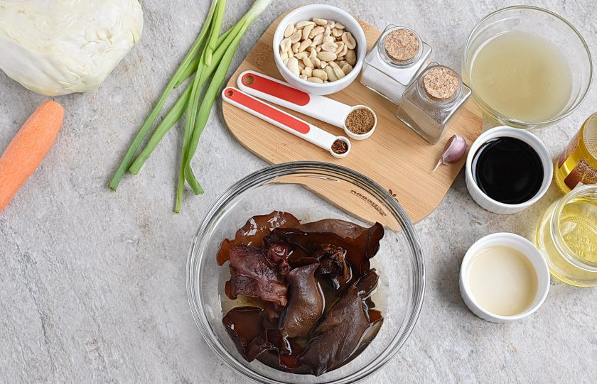 1. Этап. Китайский салат из капусты: Замочите китайские грибы в теплой воде на 10 минут. Они значительно увеличатся в размере и станут пластичными. Промойте, отрежьте корешки, если есть, обсушите и нарежьте соломкой.