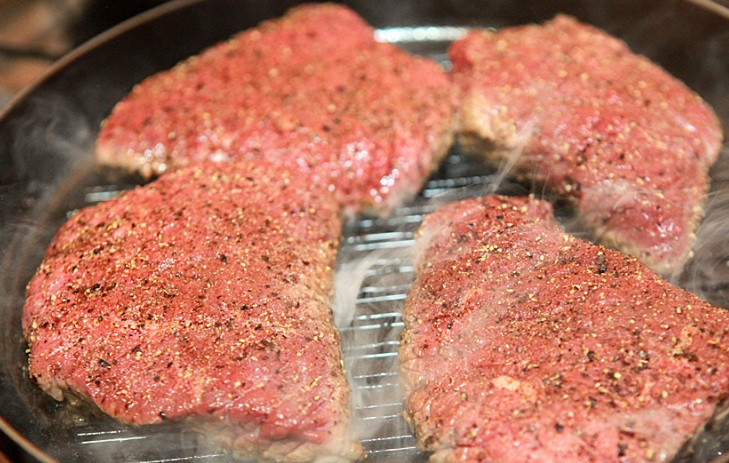 1. Этап. Говядина на сковороде гриль: Ставим сковороду гриль на огонь и хорошенько ее нагреваем, смазываем сковороду растительным маслом. Выкладываем на разогретую сковороду стейки и жарим их 2-3 минуты.