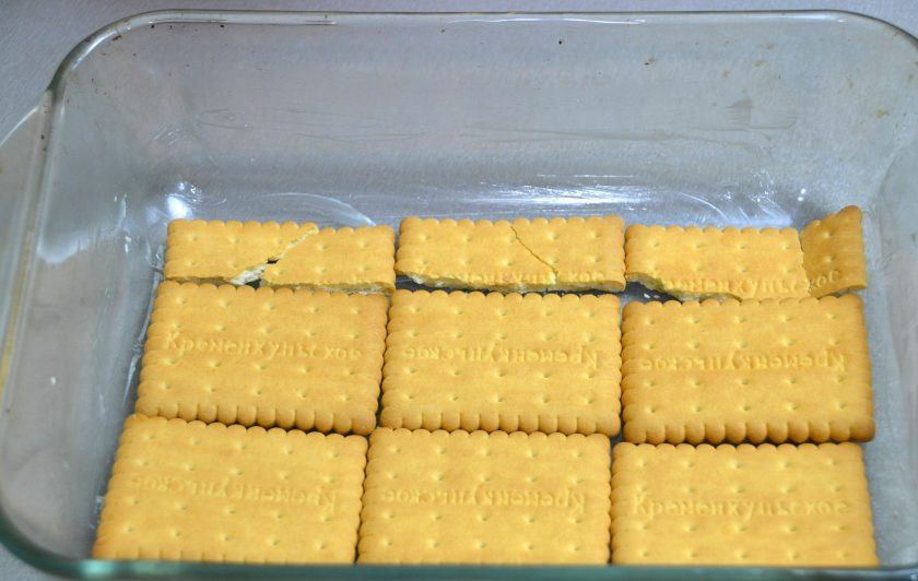 1. Этап. Дырявый пирог с клубникой: Смажьте форму сливочным маслом, на дно формы выложите печенье.