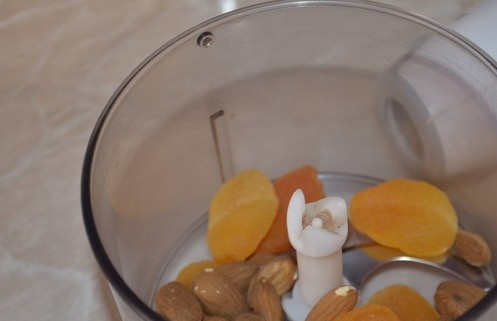 1. Этап. Чизкейк низкокалорийный: Миндаль и курагу промойте под проточной водой. Положите их в чашу блендера и хорошенько измельчите в кашицу. Затем бросьте к сухофруктам и орехам поломанное печенье, влейте растворимый кофе. Взбейте все ингредиенты еще раз.