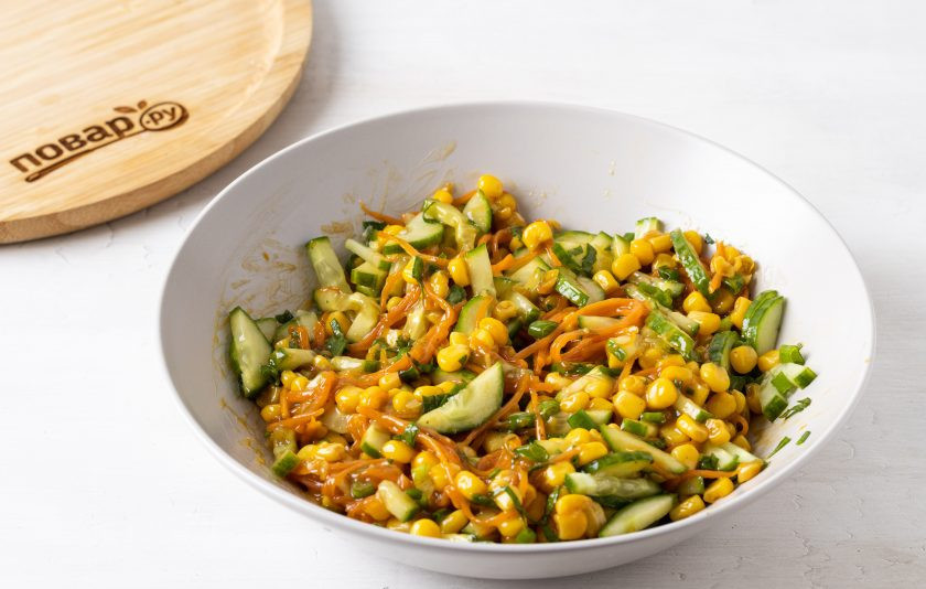 1. Этап. Салат Китайский с кукурузой: Объедините овощи из сковороды с огурцом и зеленью. Все перемешайте.