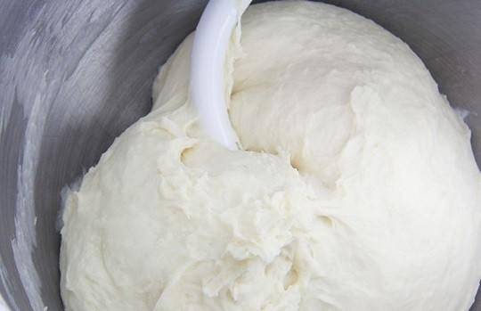 1. Этап. Хачапури по-грузински с сыром: 2. Влейте теплое молоко и начните перемешивать.