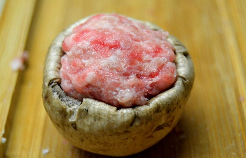 1. Этап. Фаршированные грибные шляпки: 3. Сформируйте небольшие шарики из фарша по размеру шляпки. Выложите в шляпку фарш.