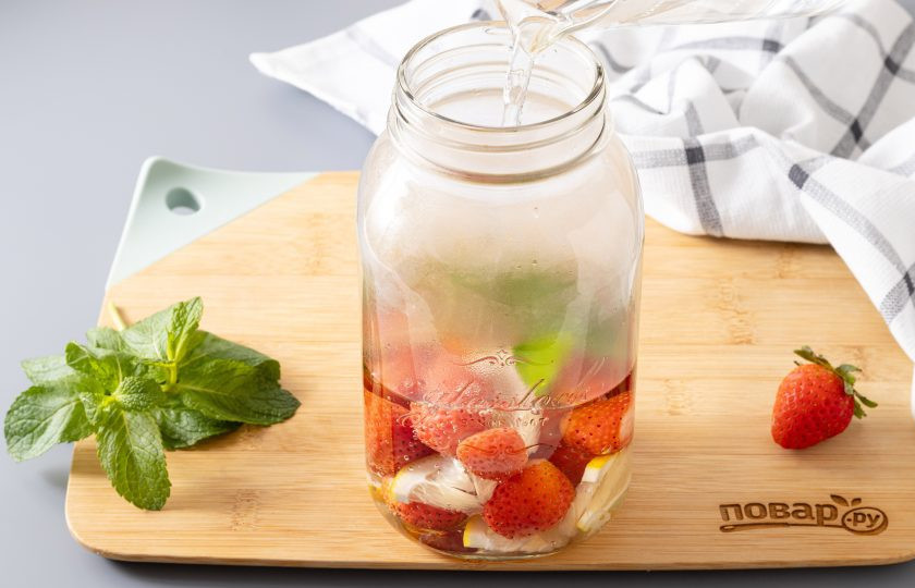 1. Этап. Компот из клубники, лимона и мяты на зиму: Влейте в банку горячую воду.