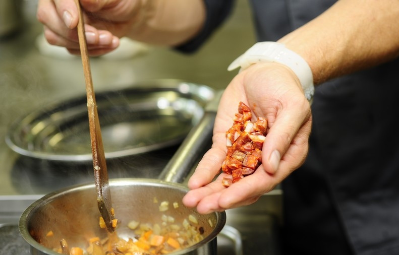 1. Этап. Суп из лисичек с фасолью: Добавляем колбасу в кастрюлю к овощам и лисичкам.