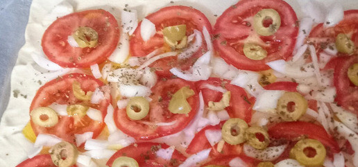 1. Этап. Тарт по мотивам греческого салата: Разогреть духовку до 210С. Нарезать помидоры тонкими слайсами 5мм толщиной каждый. Раскатать тесто и выложить помидоры, отступив 2см от каждого края. Рядом с помидорами выложить лук. Равномерно посыпать раскрошенными оливками, половиной ложки орегано и спрыснуть двумя столовыми ложками оливкового масла