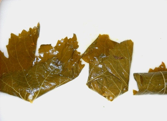 1. Этап. Постная долма (без мяса): 4. На каждый лист выложите столовую ложку начинку (или 1 чайную ложку). Сперва заверните нижнюю боковую часть, затем вторую боковую, затем сверните рулет.