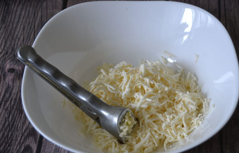 1. Этап. Сырная закуска Мандарины: Натрите на терке два плавленных сырка, выдавите через пресс зубчик чеснока.