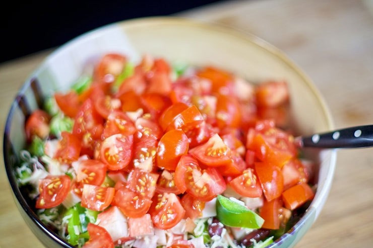 1. Этап. Cалат с крабовыми палочками и фасолью: Последними в салат с крабовыми палочками и фасолью идут помидоры. Нарежьте их мелко.