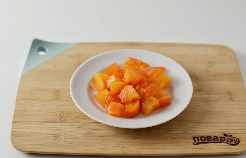 1. Этап. Салат с хурмой: Хурму нарежьте крупными кубиками, косточку удалите.