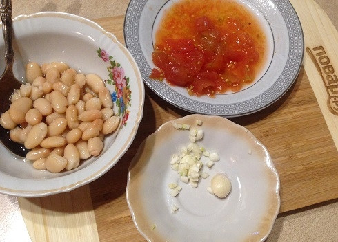 1. Этап. Суп с фасолью и шпинатом: 4. Помидоры очистим от кожуры, если она есть, и разрежем на несколько частей, 2-3 зубчика чеснока мелко нарежем и придавим ножом. Фасоль нам будет нужна без жидкости.