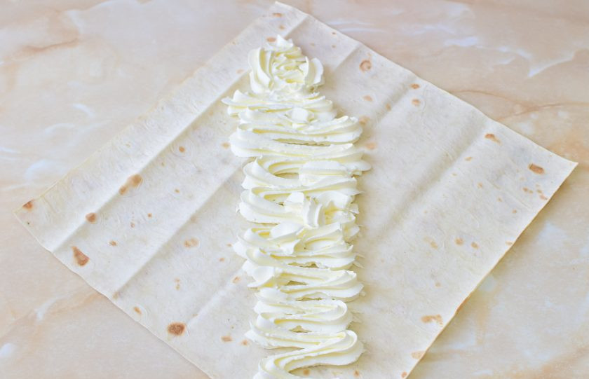 1. Этап. Сладкая шаурма: Лаваш разрежьте на кусочки необходимого размера. Нанесите на него крем.