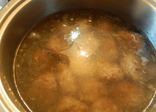 1. Этап. Юварлакья: 5. Затем в сотейник выкладываем оставшийся лук с чесноком, а сверху — фрикадельки. Заливаем водой, добавляем немного соли и на маленьком огне тушим до готовности.