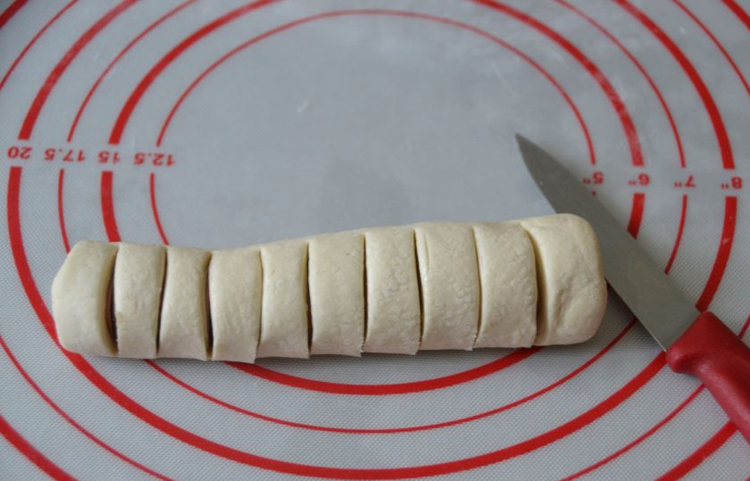 1. Этап. Сосиски в тесте Гусеницы: Плотно заверните сосиску в тесто, сделайте вертикальные разрезы, но не до самого конца теста.