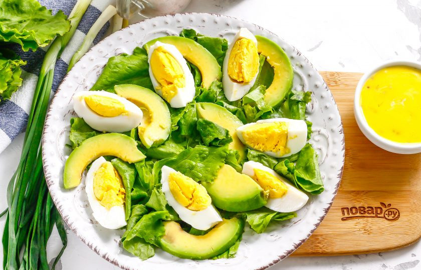 1. Этап. Салат с мидиями и авокадо: Очистите авокадо от кожуры и удалите косточку. Нарежьте мякоть слайсами и выложите на тарелку между ломтиками яичной нарезки.