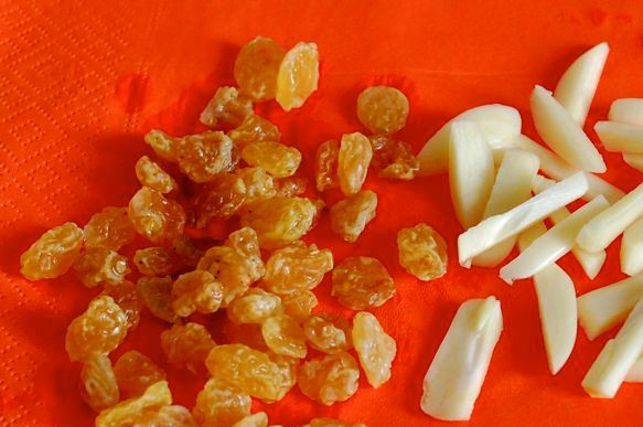 1. Этап. Телятина в микроволновке: Чеснок очищаем и режем дольками, изюм промойте и обсушите.