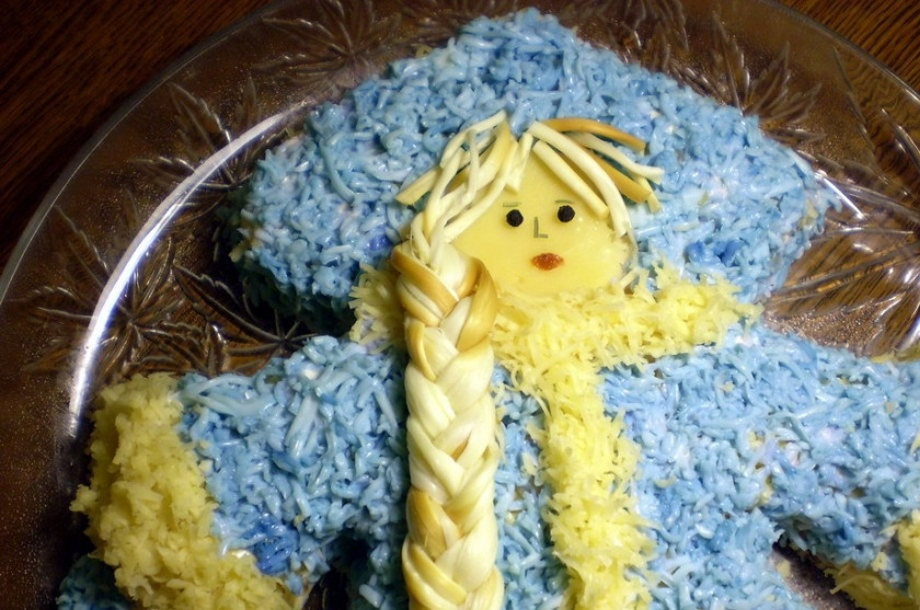 1. Этап. Салат Снегурочка: 8. Сыр лучше натереть на мелкой терке и возьмите твердые сорта. Украшаем нашу Снегурочку овощами, а косу делаем из сыра 