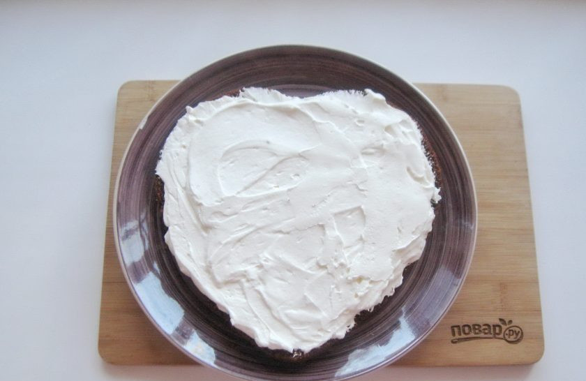 1. Этап. Торт Сердце из медовых коржей: Остывший медовый корж разрежьте на две части вдоль. Обильно смажьте кремом первый корж.