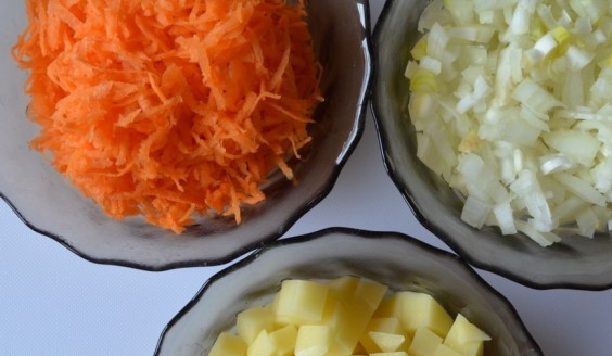 1. Этап. Сырный суп с морепродуктами: Морковь, лук и картофель помойте и очистите. Нарежьте эти овощи кубиками, кроме моркови, её натрите. Вскипятите 2 литра воды, посолите, вкиньте лавровый лист и картофель. Варите 15 минут на небольшом огне.