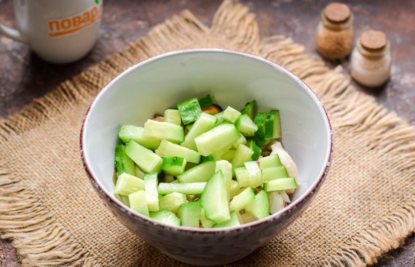 1. Этап. Салат из морского коктейля: Свежий огурец ополосните и просушите, обрежьте концы с обеих сторон. Нарежьте огурец небольшими полосками или кубиками, добавьте к морскому коктейлю.