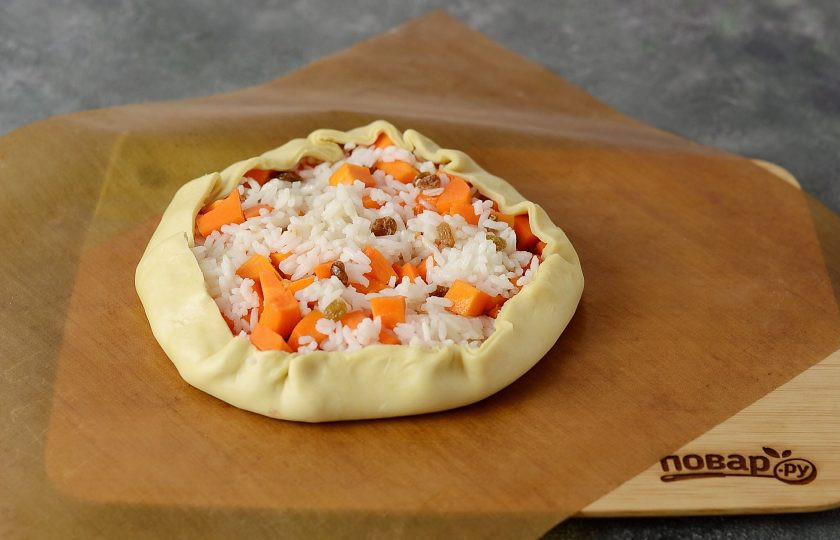 1. Этап. Бэлиш с тыквой: Для основы пирога возьмите 2/3 теста, раскатайте. В центр выложите начинку и немного поднимите края теста к центру.