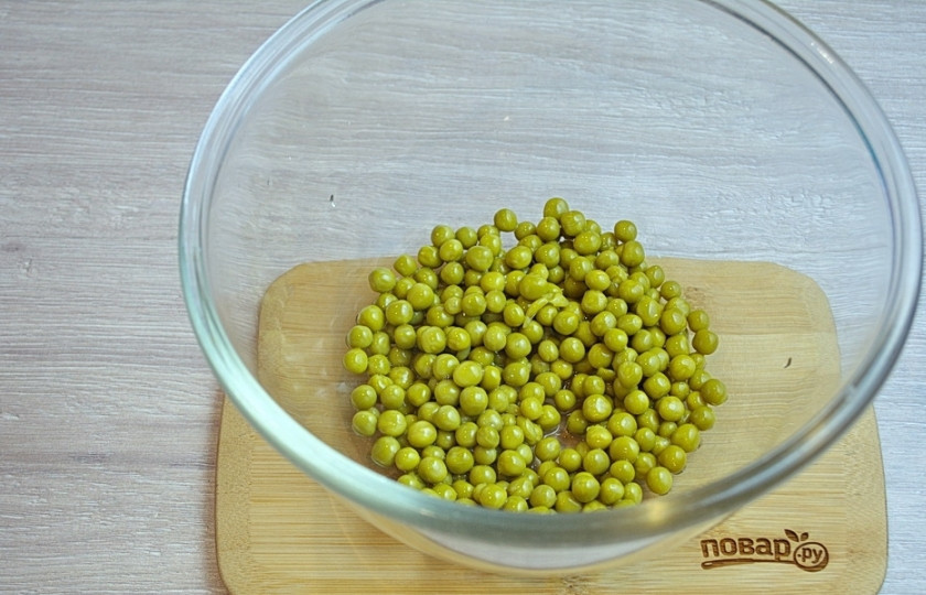 1. Этап. Новогодний салат Куранты: 1. Для приготовления салата откройте банку с горошком. Слейте рассол, горошек без жидкости поместите в миску.