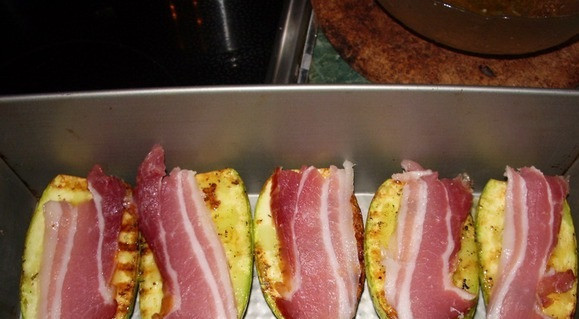 1. Этап. Кабачки с беконом: Выложите кабачки на противень. Сверху на каждый кладем по ломтику бекона. Ставим запекаться в духовку, температура 180 градусов. Запекаем до готовности кабачков.