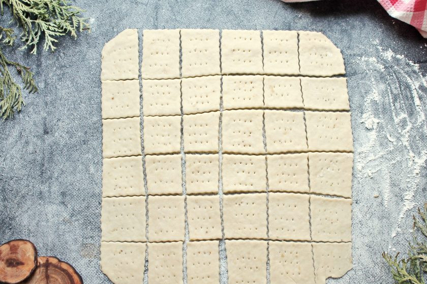 1. Этап. Крекеры с бананом: Тесто немного посыпьте мукой и раскатайте тесто в прямоугольник толщиной не толще 5 мм. Разрежьте на квадратики и каждый наколите вилкой.