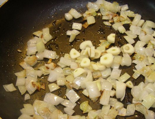 1. Этап. Гуляш из кролика с подливкой: Минут через 5, когда лук начнет слегка подрумяниваться, добавляем очищенный и измельченный чеснок. Обжариваем буквально 1-2 минуты.