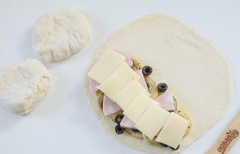 1. Этап. Кальцоне с цукини, оливками и моцареллой: Положите ломтики моцареллы.