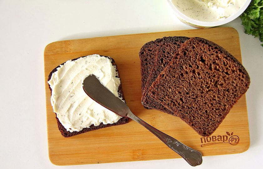 1. Этап. Бутерброды с бужениной: Нарежьте 4 кусочка хлеба, я брала черный (уже в нарезке). Намажьте хлеб нежным творожным сыром, у меня сыр был сразу с зеленью. По желанию творожный сыр можно заменить сливочным или вовсе взять сливочное масло.