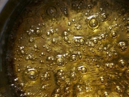 1. Этап. Торт Крокембуш: 8. Самый опасный этап - приготовление карамели. Она гораздо горячее воды, и при приготовлении надо быть осторожным, но без нее не обойтись, ведь шарики надо склеить и сделать воздушную мишуру на елку. Или иней... Возьмем маленькую кастрюльку, засыпем сахар, немного смочим его водой. Сахар быстро растает и начнет кипеть. Как только он зажелтеет, его можно выключать, нужно выжать в него сок половинки лимона. Это наша карамель. Ей надо дать остыть, и можно использовать как связующее вещество.