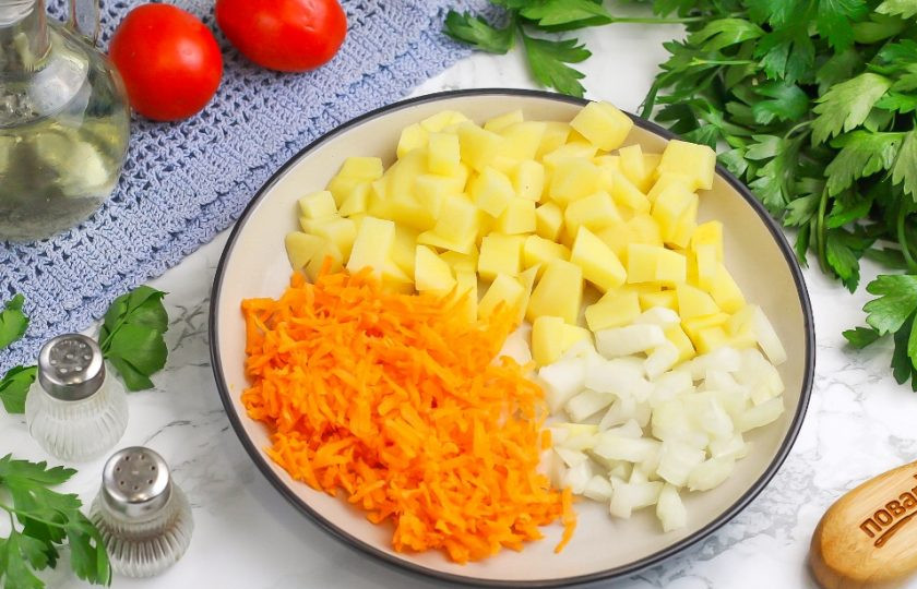 1. Этап. Чечевичный суп с курицей: Нарежьте картофель средними кубиками, лук — мелкими, а морковь натрите на терке с мелкими ячейками. По желанию можно натереть и лук. Выложите в кастрюлю и отварите в течение 10 минут.