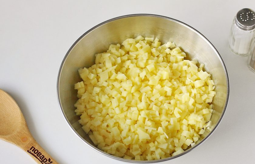 1. Этап. Начинка для вареников: Картофель очистите и нарежьте мелкими кубиками, чем мельче получится, тем лучше. Сначала картофель положите в воду, затем откиньте на сито и переложите в глубокую миску.