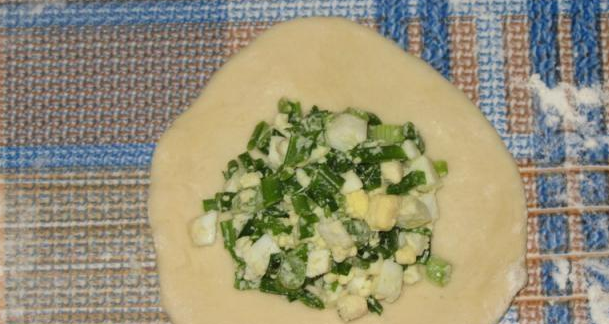 1. Этап. Жареные пирожки с луком: Обваляйте каждый кусочек в муке и раскатайте его в лепешку. В центр каждой лепешки выложите начинку.