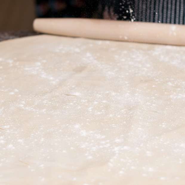 1. Этап. Норин: Посыпать немного муки на рабочую поверхность и раскатать тесто в тонкий широкий блин.