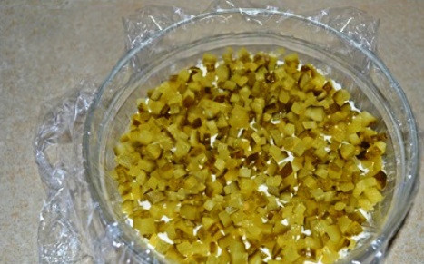 1. Этап. Салат для праздничного стола: Смазываем картофель соусом (смесь майонеза, сливок, соли и черного молотого перца). Затем выкладываем нарезанные кубиком соленые огурцы.