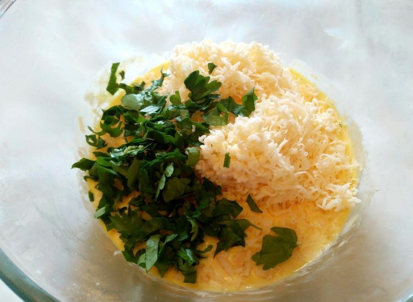 1. Этап. Квише с овощной начинкой: Пока тушёные овощи остывают, приготовьте смесь из двух яиц, второй половины тёртого сыра, сметаны, щепотки соли и мелко нарезанной зелени петрушки.