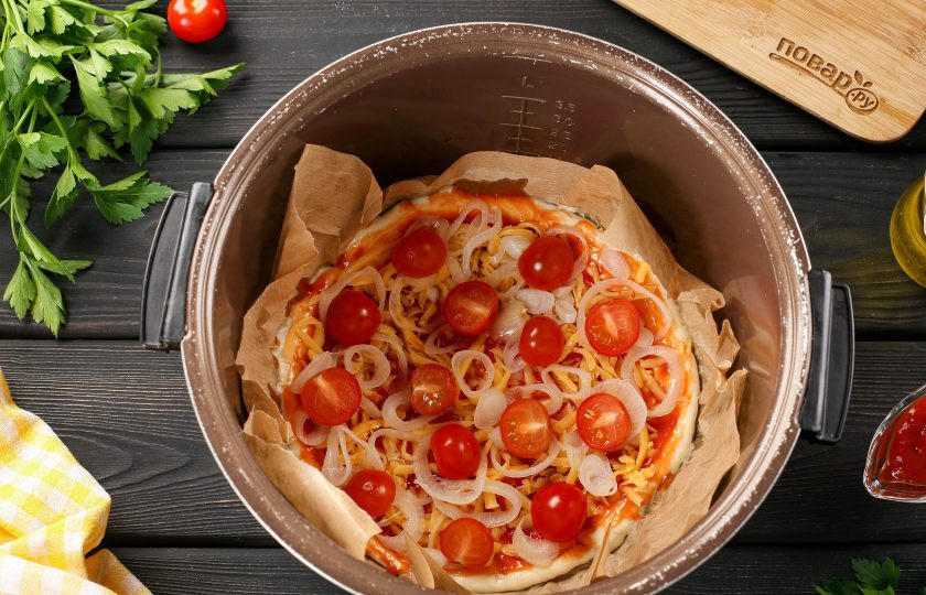 1. Этап. Пицца с сыром в мультиварке: Сверху разложите начинку. У меня лук, нарезанный колечками и помидоры черри. Лук предварительно можно замариновать или ошпарить кипятком, чтобы убрать горечь.