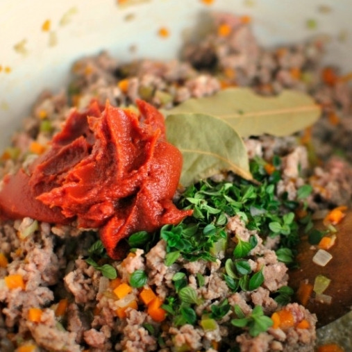 1. Этап. Болоньезе: 4. К готовому мясу добавьте лавровые листья, тимьян и томатную пасту.