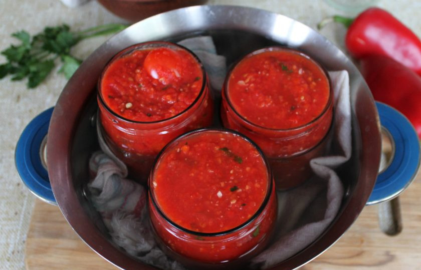 1. Этап. Помидоры в аджике на зиму: Кипящую аджику разливаем по банкам с помидорами. В кастрюлю добавляем горячую воду. Вода должна доходить до 