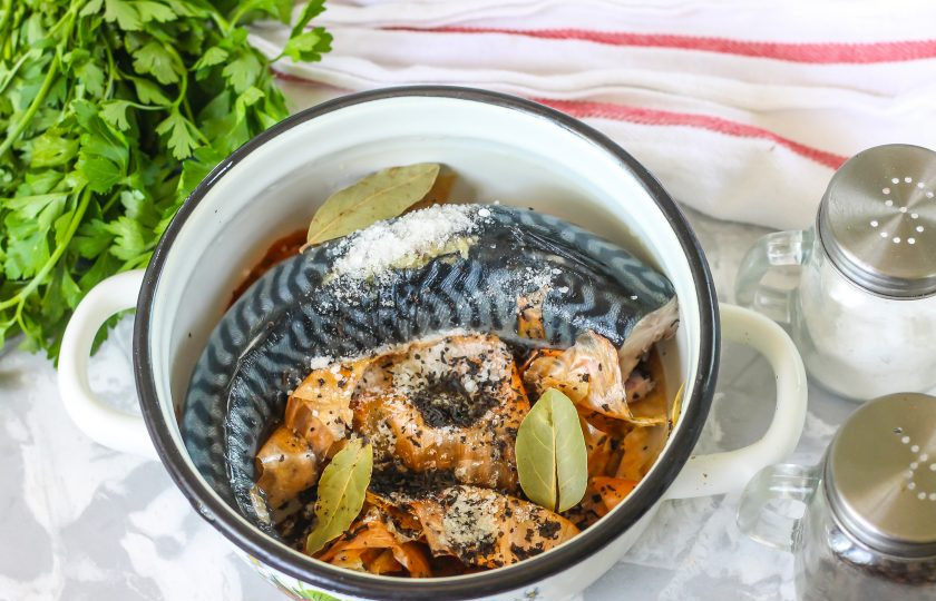 1. Этап. Скумбрия в луковой шелухе и чайной заварке: Скумбрию промойте в воде, срежьте голову и хвост, выпотрошите и тщательно промойте внутри, удаляя с боков черную плеву. Выложите в казан или кастрюлю луковую шелуху, на нее поместите промытую рыбу. Нарезать тушку на куски не нужно - блюдо будет непривлекательно выглядеть после варки. Всыпьте чайную заварку - лучше всего использовать чайный пакетик. Добавьте соль, молотый черный перец, лавровые листья.