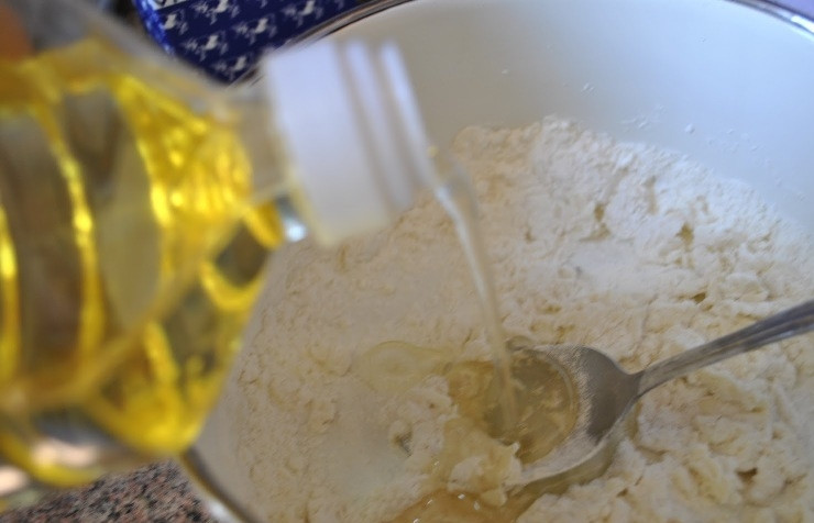 1. Этап. Куриные ножки в кляре: Добавляем молоко (можно заменить сметаной или майонезом) и вливаем одну чайную ложку масла.