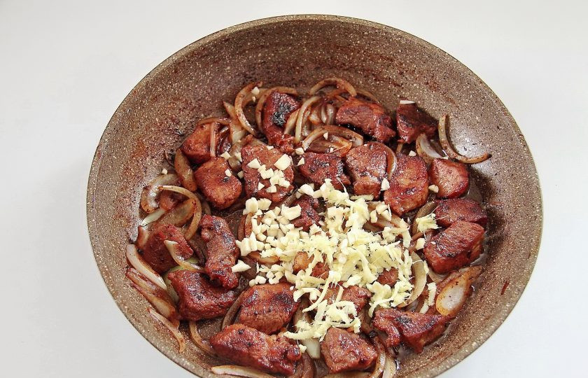 1. Этап. Жаркое из свинины и зеленой фасоли: Добавьте измельченный ножом чеснок и тертый на крупной терке корень имбиря.