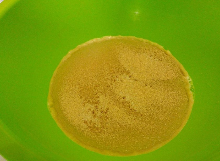 1. Этап. Постные гороховые пирожки: Влейте в пюре воду и, убедившись в том, что масса тёплая (температура 30-35 градусов), всыпьте в неё дрожжи и сахар, размешайте.